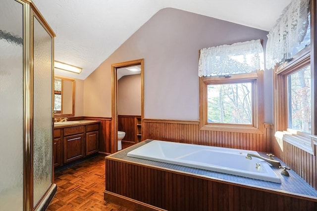 full bathroom featuring parquet floors, vanity, vaulted ceiling, shower with separate bathtub, and toilet