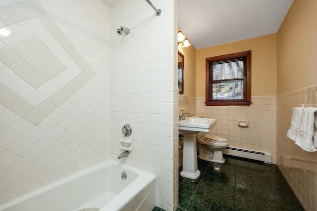 full bathroom with a baseboard heating unit, tile patterned floors, tiled shower / bath combo, toilet, and tile walls