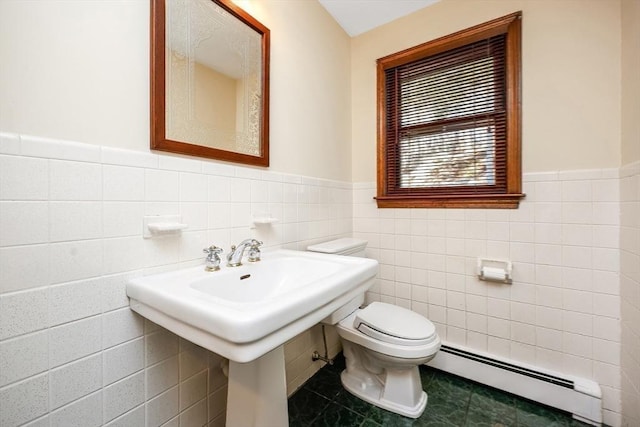 bathroom with baseboard heating, tile patterned flooring, tile walls, and toilet