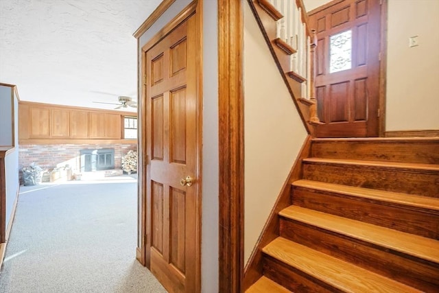 stairway with carpet flooring and ceiling fan