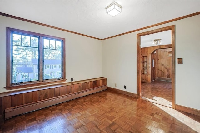 unfurnished room featuring baseboard heating, crown molding, and parquet floors