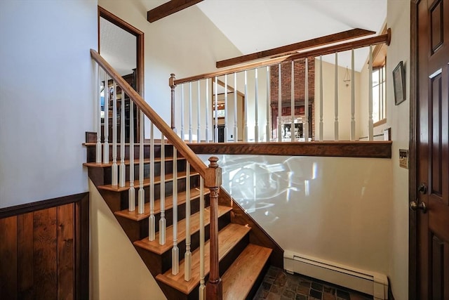 stairway with lofted ceiling, wooden walls, and a baseboard heating unit