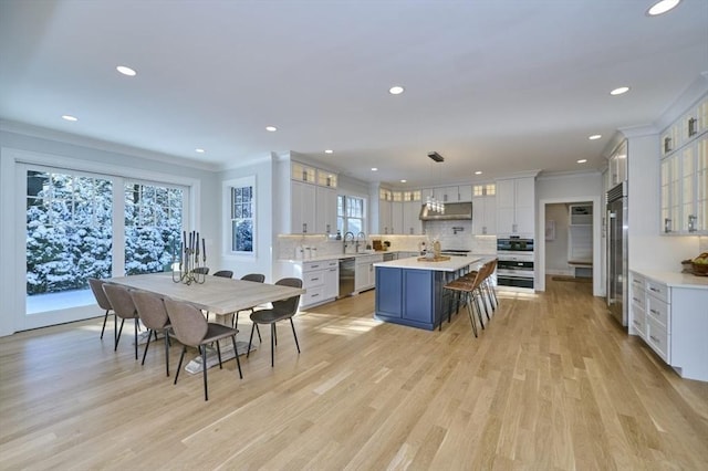 kitchen featuring white cabinets, a kitchen island, black dishwasher, and pendant lighting