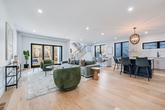 living room with a chandelier and light wood-type flooring