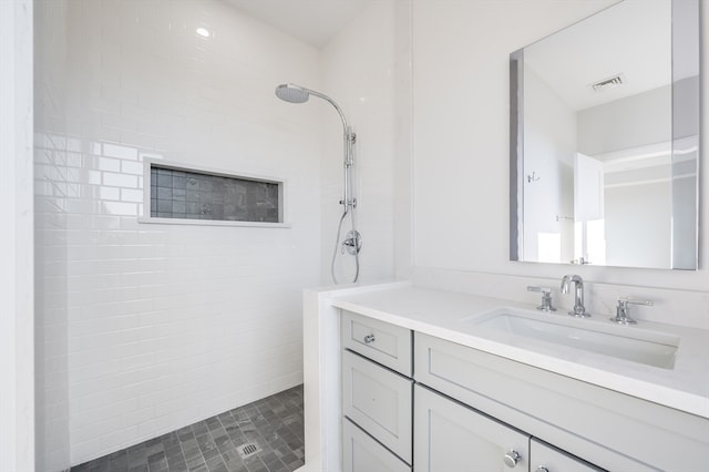 bathroom featuring oversized vanity and a tile shower