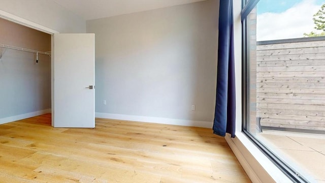 191 Washington St Unit 309, Boston, MA 02135 - unfurnished bedroom featuring light wood finished floors, multiple windows, and baseboards