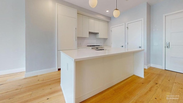 191 Washington St Unit 309, Boston, MA 02135 - kitchen with light wood-style flooring, light countertops, backsplash, pendant lighting, and recessed lighting