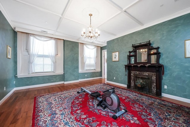 sitting room with hardwood / wood-style floors, an inviting chandelier, and coffered ceiling