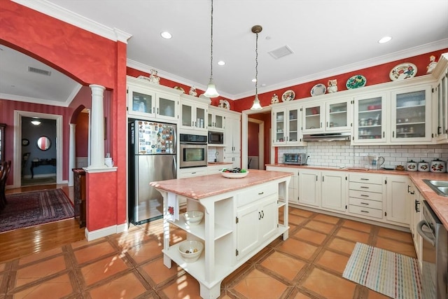 kitchen with a center island, pendant lighting, appliances with stainless steel finishes, light tile patterned floors, and ornate columns