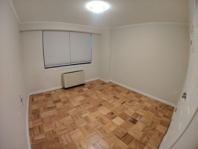 unfurnished room featuring baseboards, ornamental molding, and radiator