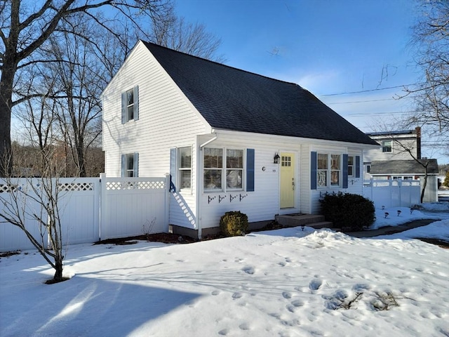 view of front of home featuring roof with shingles and fence