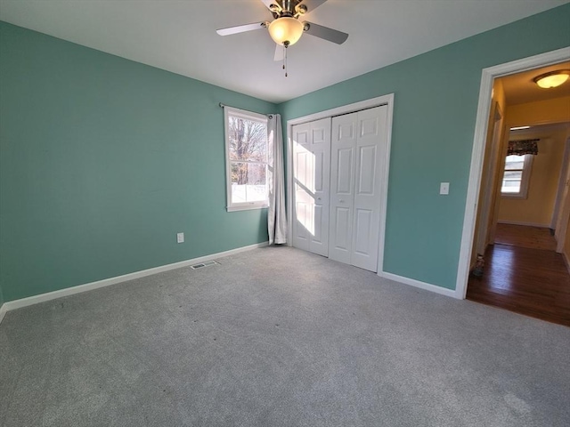 unfurnished bedroom featuring carpet, a closet, visible vents, and baseboards