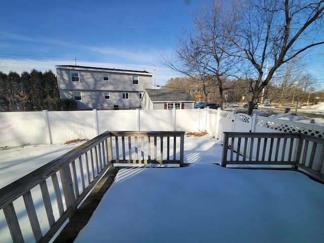 snow covered deck featuring a fenced backyard