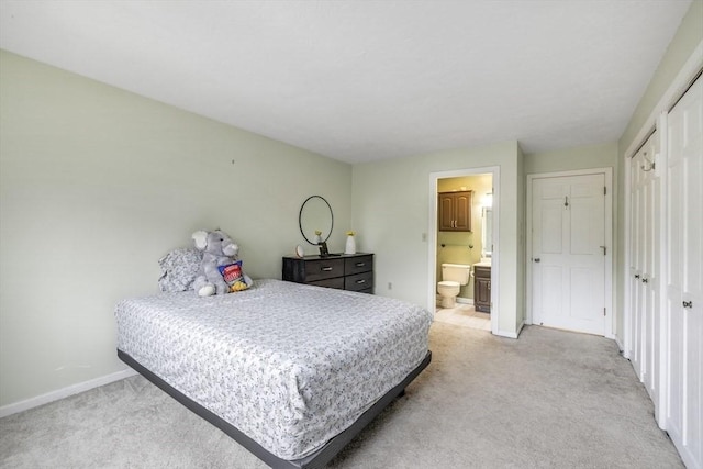 bedroom with carpet flooring, ensuite bath, and baseboards