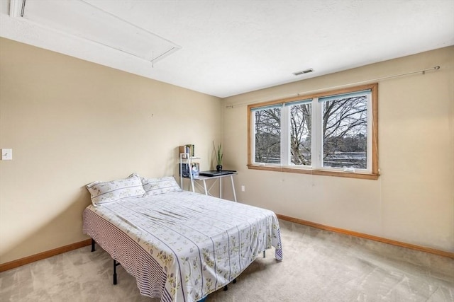 carpeted bedroom featuring visible vents, attic access, and baseboards