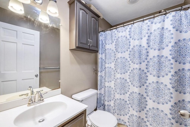 bathroom featuring curtained shower, toilet, and vanity