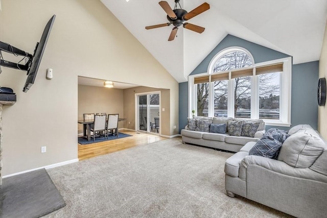 living room featuring baseboards, carpet floors, and high vaulted ceiling