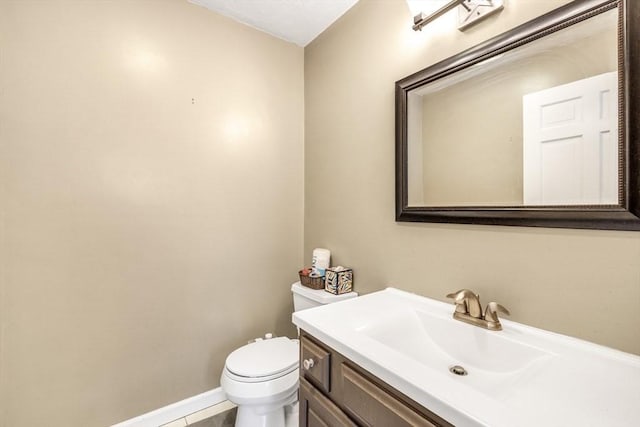 half bath with vanity, toilet, and baseboards