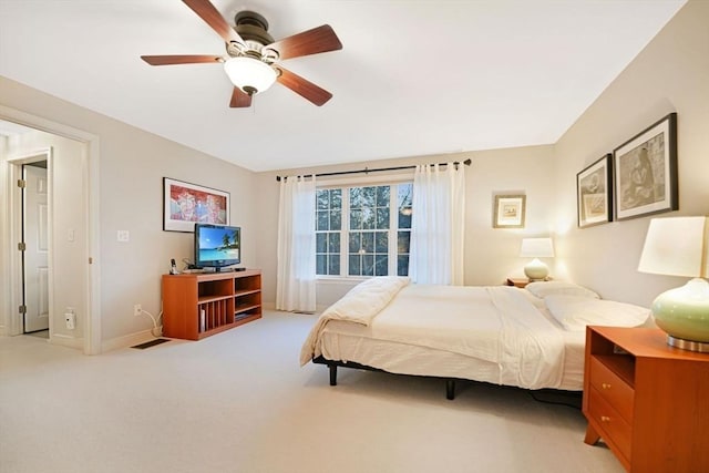 bedroom featuring light carpet, ceiling fan, and baseboards