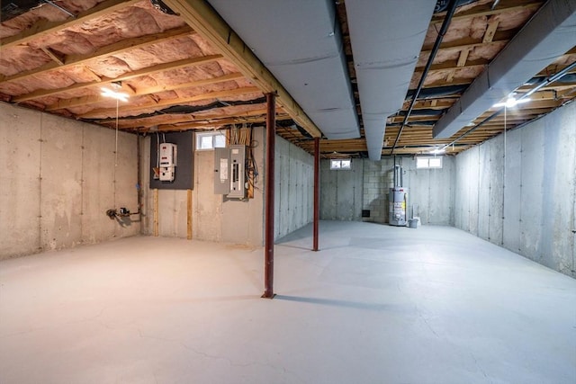 basement featuring electric panel and water heater