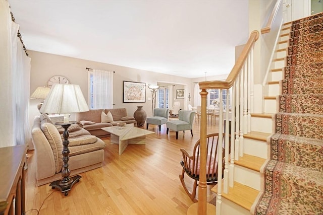 living room featuring light wood finished floors and stairs