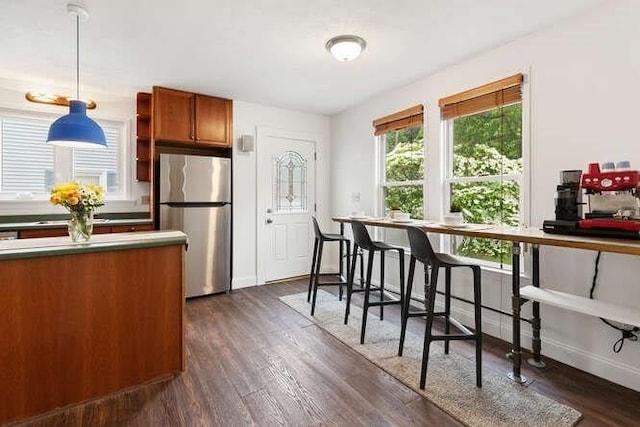 6 Francis Ave, Wakefield, MA 01880 - kitchen featuring freestanding refrigerator, brown cabinets, hanging light fixtures, dark wood finished floors, and baseboards