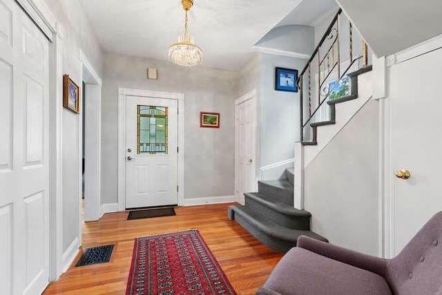 6 Francis Ave, Wakefield, MA 01880 - foyer entrance with stairs, light wood finished floors, a chandelier, and baseboards