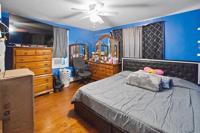 bedroom featuring ceiling fan, cooling unit, and hardwood / wood-style floors