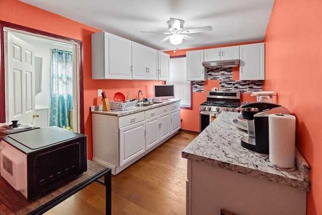 kitchen featuring light hardwood / wood-style floors, a wealth of natural light, gas range, and white cabinets