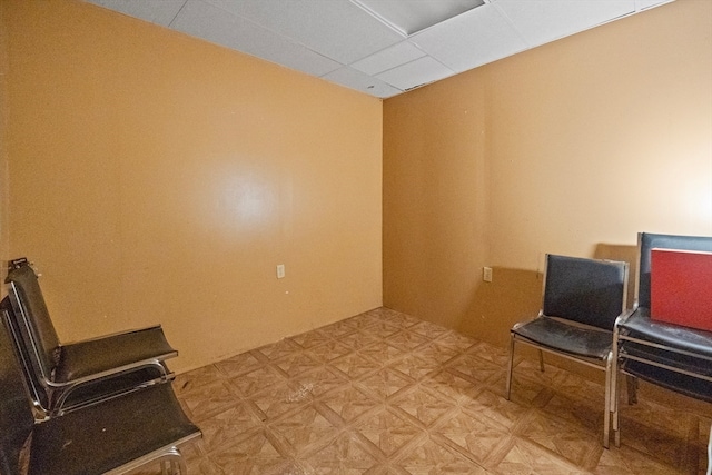 living area with a paneled ceiling