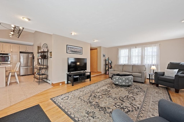 living area with light wood-style flooring and baseboard heating