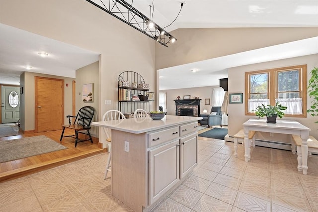 kitchen featuring light countertops, a fireplace, open floor plan, a chandelier, and a center island
