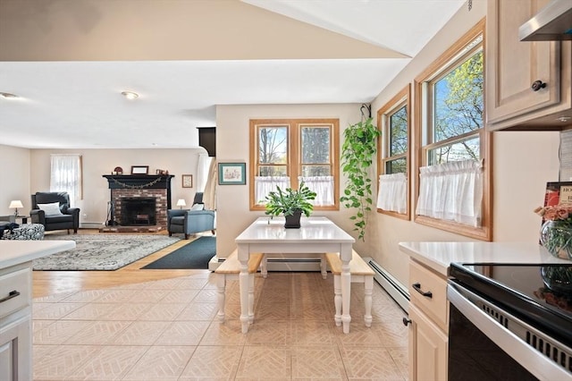 living room with a brick fireplace, baseboard heating, lofted ceiling, and baseboards
