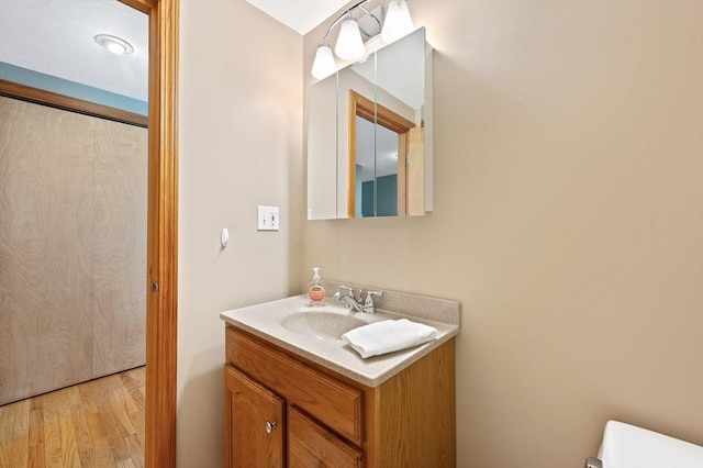 bathroom featuring wood finished floors, vanity, and toilet