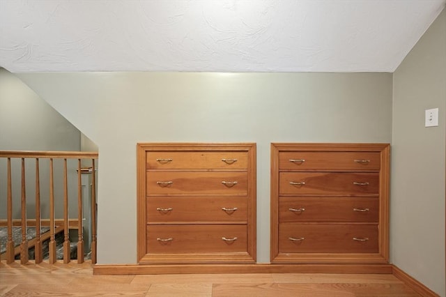 bonus room with light wood-style flooring, baseboards, and vaulted ceiling