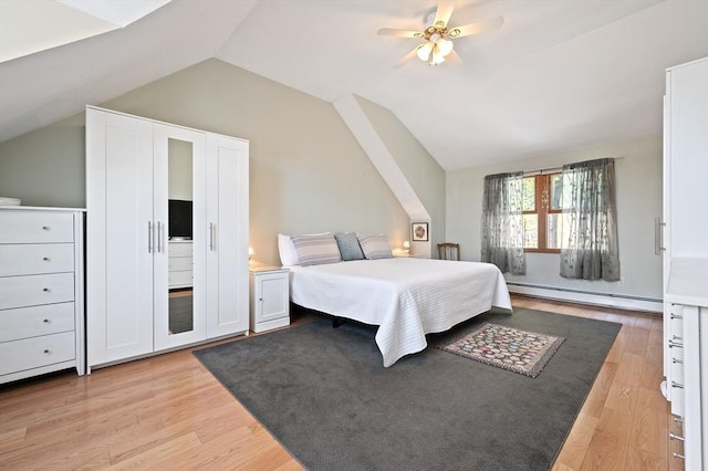 bedroom with a baseboard heating unit, lofted ceiling, light wood finished floors, and a ceiling fan