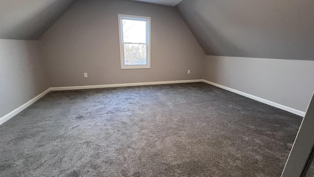 additional living space featuring lofted ceiling and dark carpet