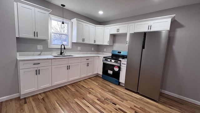 kitchen with light stone countertops, appliances with stainless steel finishes, sink, and white cabinetry