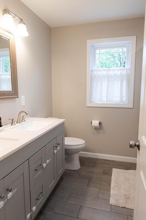 82 Davenport St, Springfield, MA 01119 - bathroom featuring double vanity, toilet, baseboards, and wood finished floors