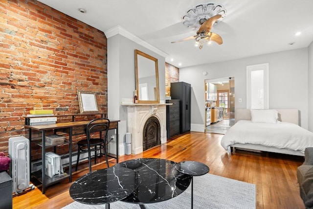 15 Concord Sq Unit 1A, Boston, MA 02118 - bedroom with a fireplace, light wood-style flooring, baseboards, and brick wall
