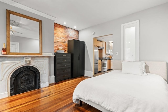 15 Concord Sq Unit 1A, Boston, MA 02118 - bedroom with wood finished floors, stainless steel refrigerator, recessed lighting, baseboards, and brick wall