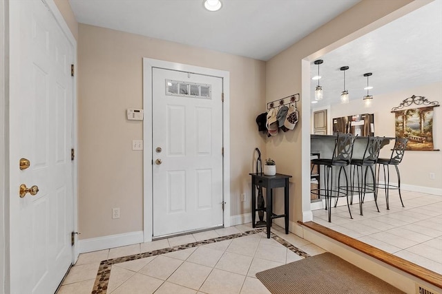 foyer with light tile patterned flooring and baseboards