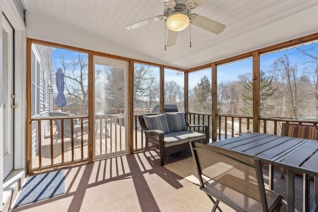 sunroom featuring vaulted ceiling, a ceiling fan, and a healthy amount of sunlight