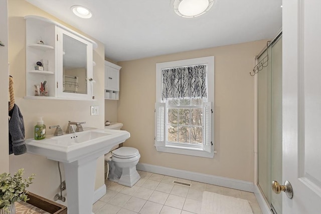 bathroom with a stall shower, baseboards, visible vents, toilet, and tile patterned flooring