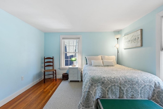 bedroom with wood finished floors and baseboards