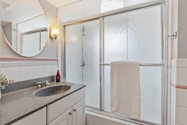 bathroom with visible vents, shower / bath combination with glass door, and vanity