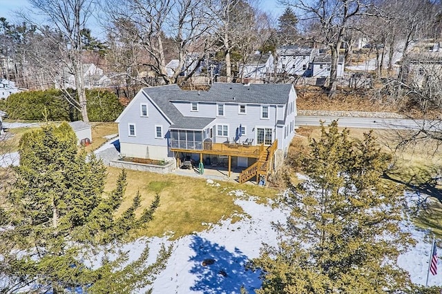 back of house featuring stairs, a yard, a deck, and a sunroom