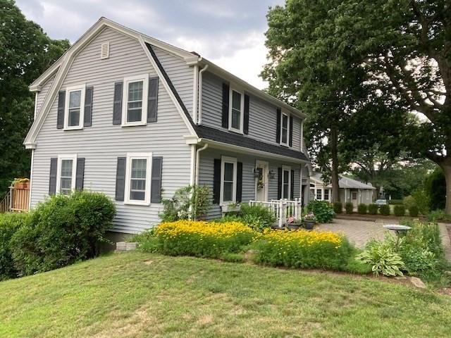 rear view of house with a lawn and a gambrel roof