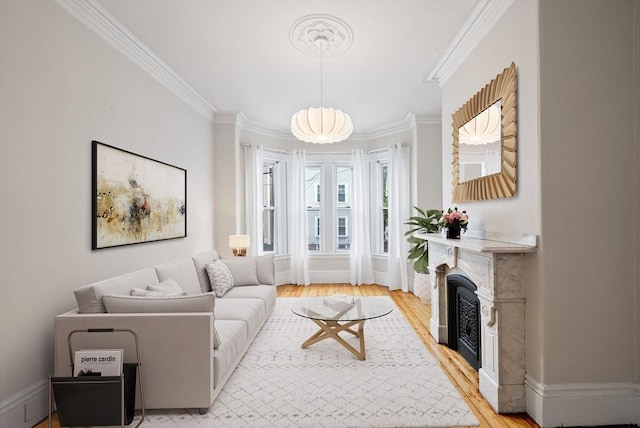 living area featuring ornamental molding, light wood finished floors, and a fireplace