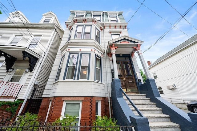 victorian home with fence and brick siding